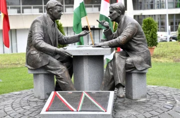 zdjęcie przedstawia pomnik dwóch ludzi siedzących przy stole.