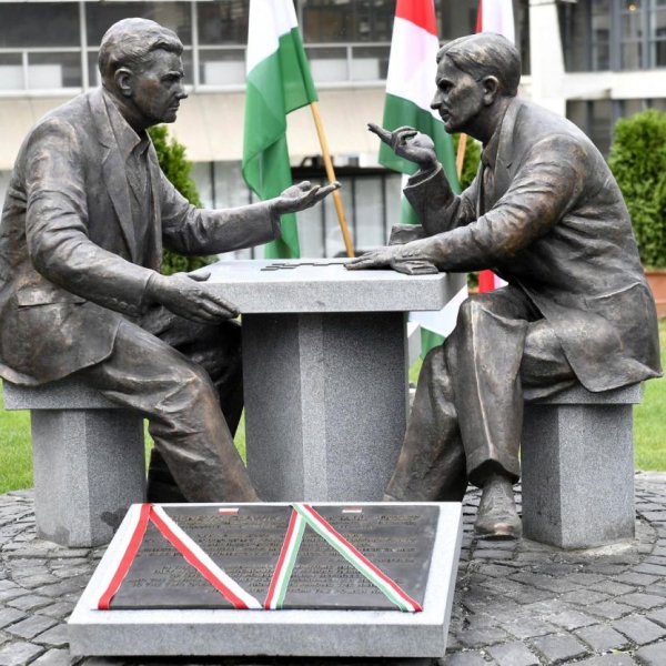 zdjęcie przedstawia pomnik dwóch ludzi siedzących przy stole.