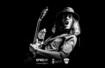 grafika przedstawia muzyka w kapeluszu z gitarą.