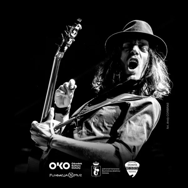 grafika przedstawia muzyka w kapeluszu z gitarą.