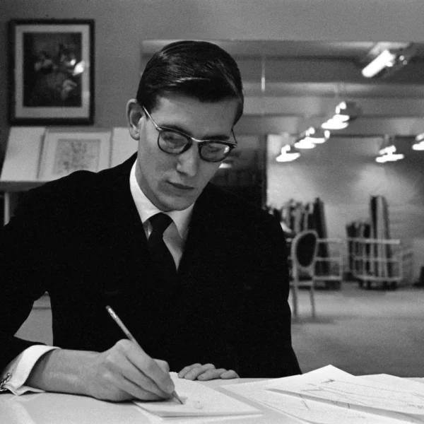 Zdjęcie przedstawia mężczyznę siedzącego przy biurku i prawą ręką podpisuje dokument