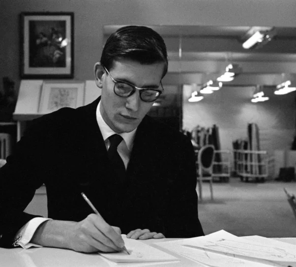 Zdjęcie przedstawia mężczyznę siedzącego przy biurku i prawą ręką podpisuje dokument