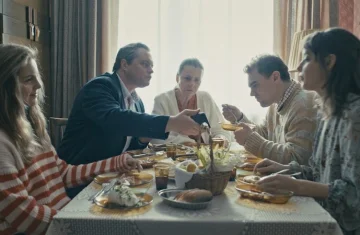 kard z filmu Dom dobry, ludzie siedzą przy stole i jedzą obiad
