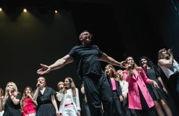 zdjęcie przedstawia artystów śpiewających na scenie.