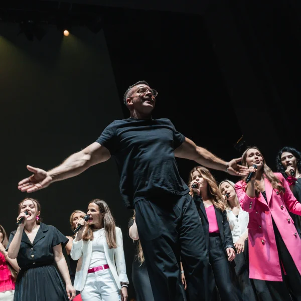 zdjęcie przedstawia artystów śpiewających na scenie.