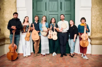 zdjęcie przedstawia 8 artystów stojących pod zielonymi drzwiami