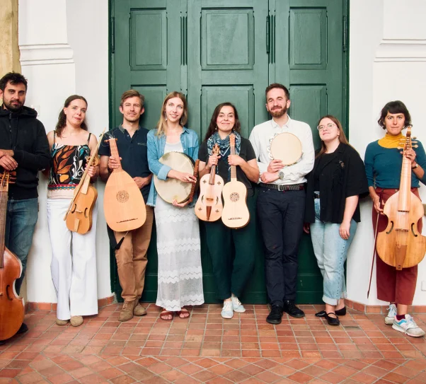 zdjęcie przedstawia 8 artystów stojących pod zielonymi drzwiami