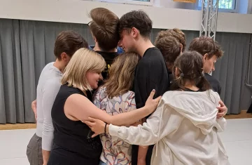grupa ok. 10 osób przytula się do siebie