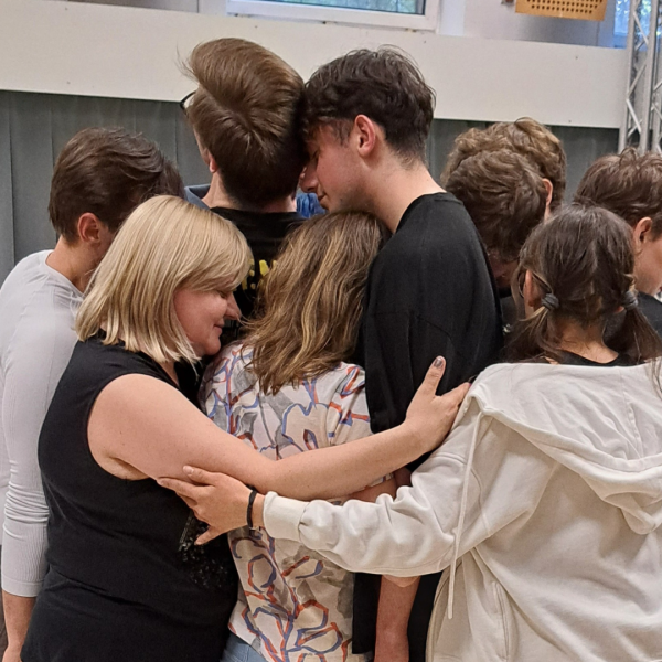 grupa ok. 10 osób przytula się do siebie