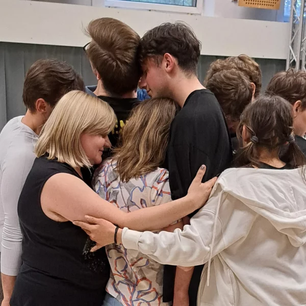 grupa ok. 10 osób przytula się do siebie