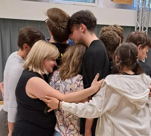 grupa ok. 10 osób przytula się do siebie