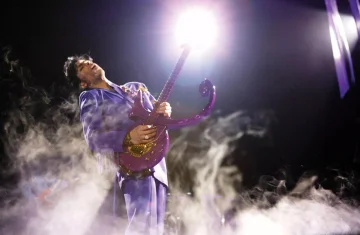 zdjęcie przedstawia Princ'a grającego na gitarze