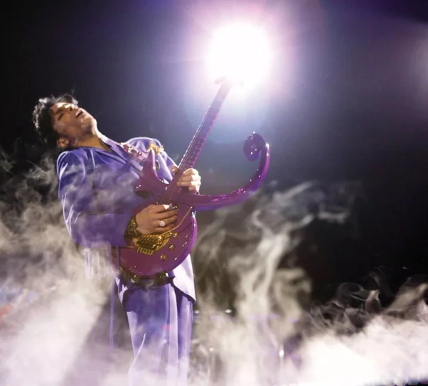 zdjęcie przedstawia Princ'a grającego na gitarze