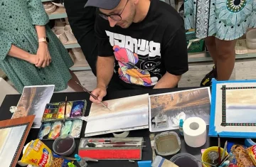 zdjęcie przedstawia artystę, który pokazuje kursantom jak stworzyć pracę