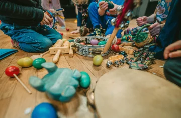 zdjęcie przedstawia dzieci siedzących przy instrumentach