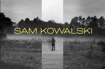 Szare zdjęcie na zewnątrz z jaśniejszym prostokątem, na środku stoi mężczyzna. Na środku zdjęcia wielkimi, żółtymi literami napisano tytuł "Sam Kowalski"
