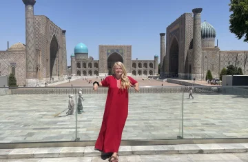 Kobieta w czerwonej sukience, w tle plac Registan w Samarkandzie w Uzbekistanie