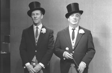 czarno białe zdjęcie przedstawia dwie postaci mężczyzn ubranych elegancko we fraki